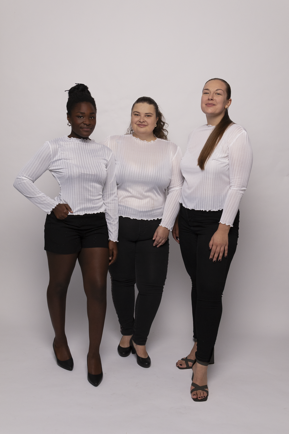 Die drei Models mit den Konfektionsgrößen 38, 52 und 46 (von links nach rechts) tragen das transparente Langarmshirt der Kollektion.